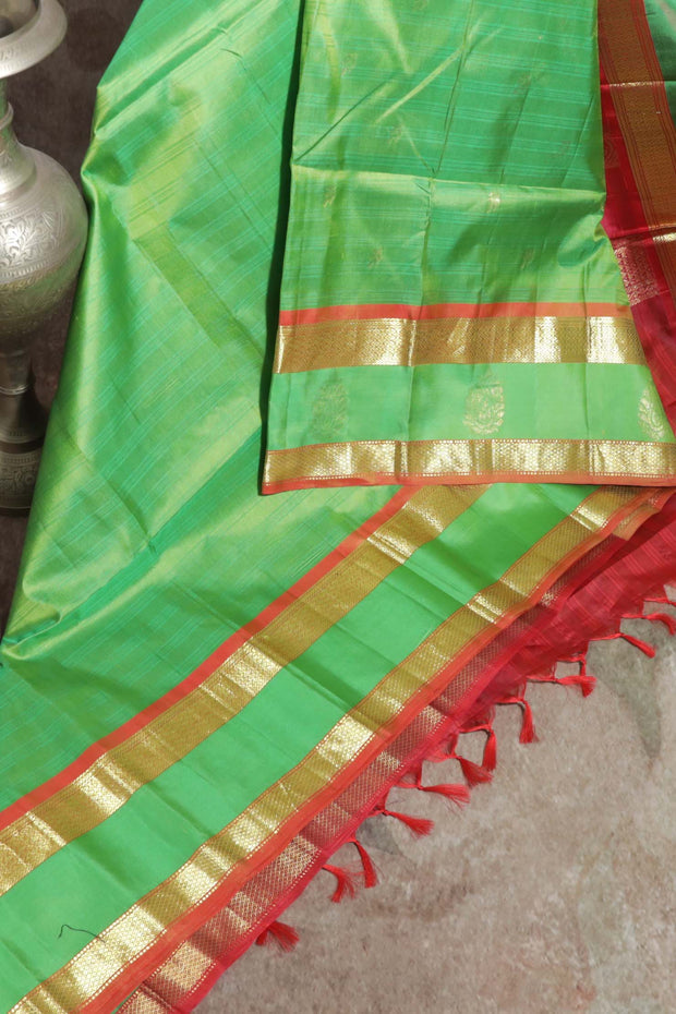 Light green and orange Kanchivaram saree with purple border, stitched blouse