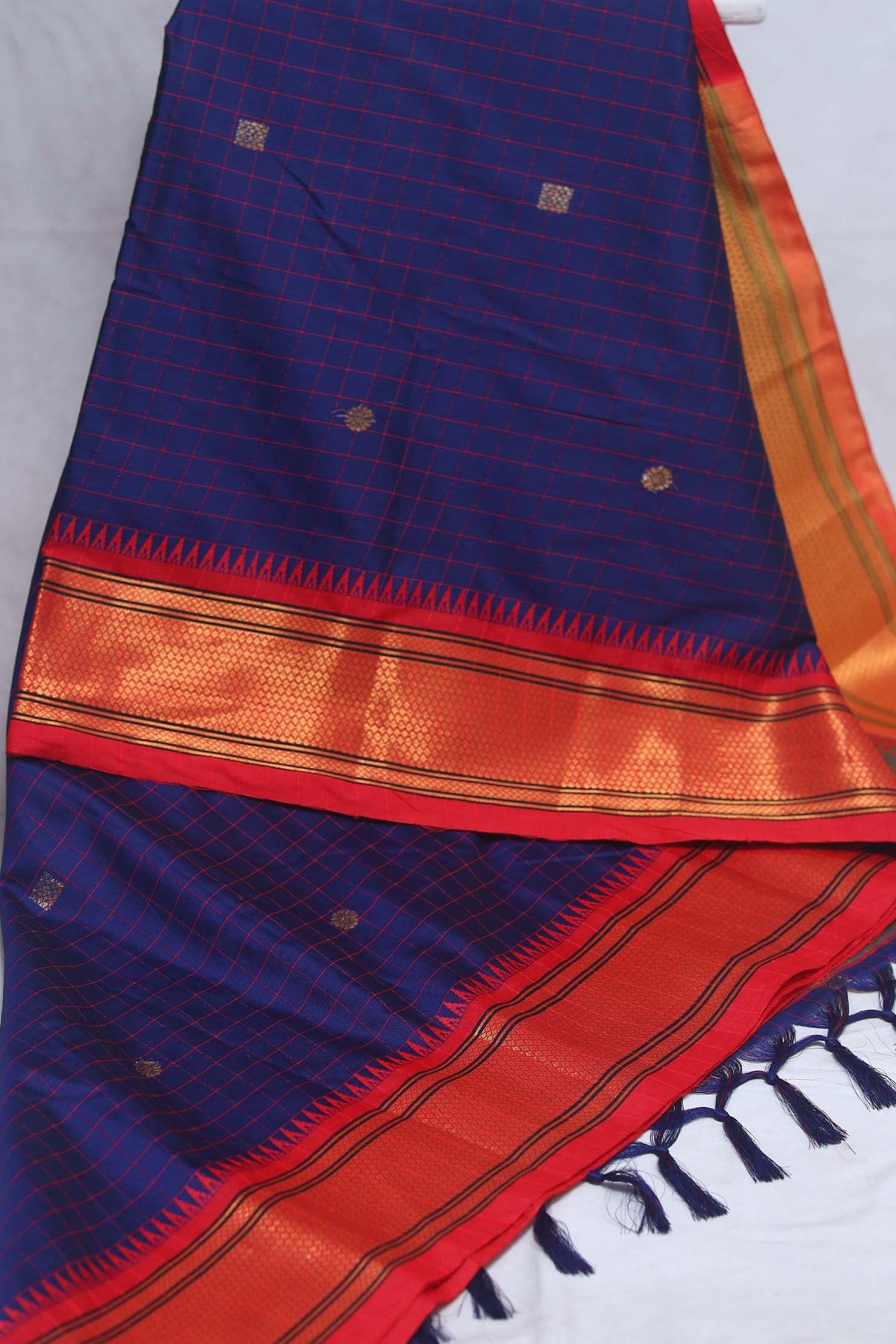 Navy blue semi silk saree with orange temple border, with stitched blouse