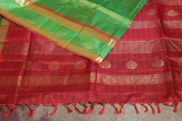 Light green and orange Kanchivaram saree with purple border, stitched blouse