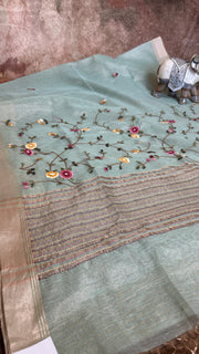 Light green tissue linen saree with hand emroidery and stitched blouse