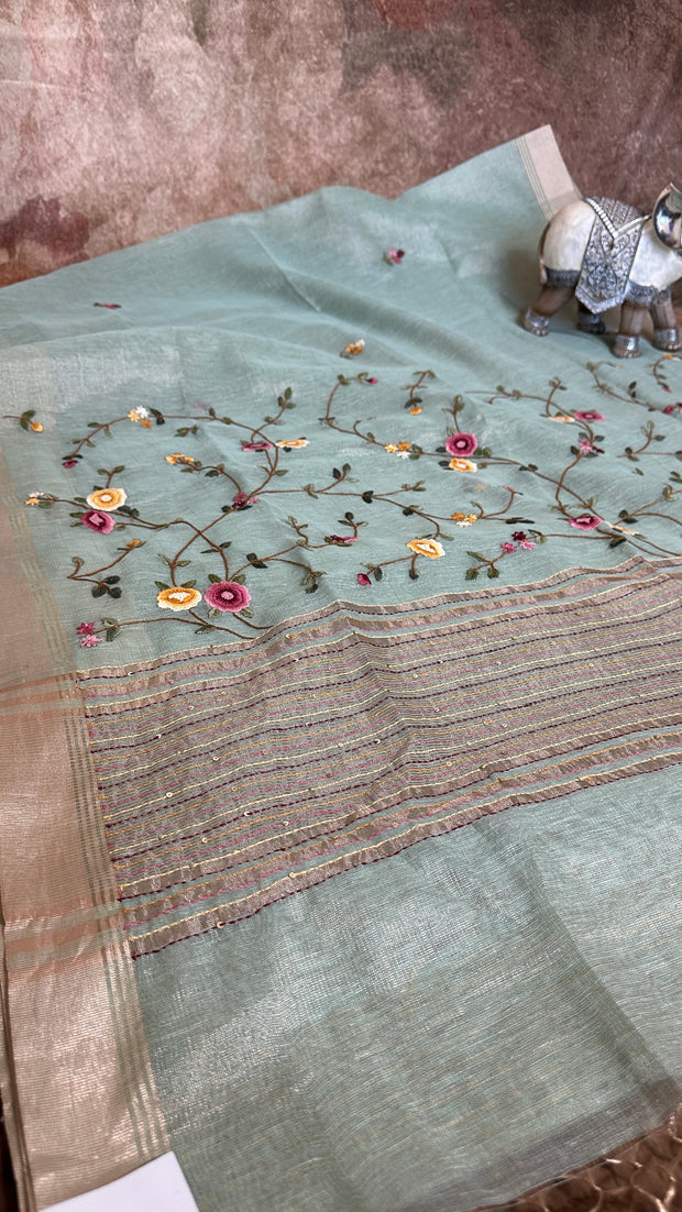 Light green tissue linen saree with hand emroidery and stitched blouse