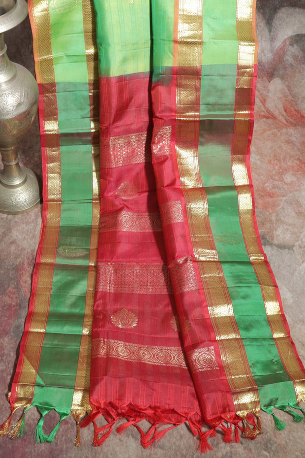 Light green and orange Kanchivaram saree with purple border, stitched blouse