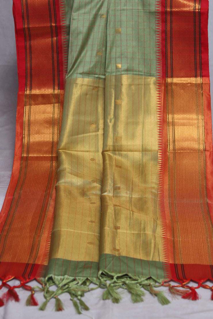 Light green semi silk saree with orange temple border, with stitched blouse