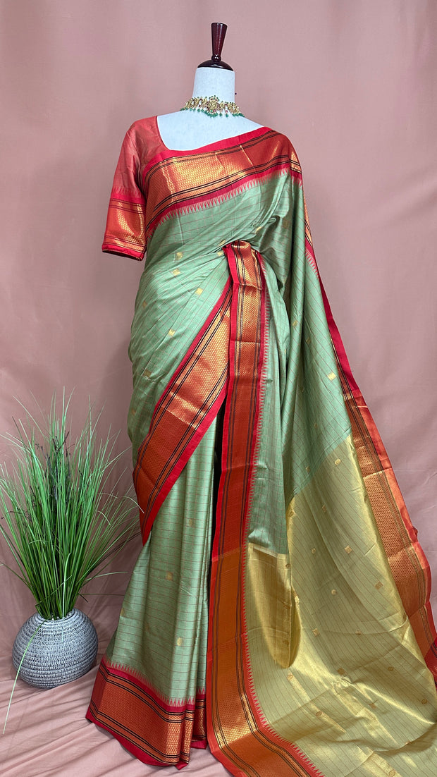 Light green semi silk saree with orange temple border, with stitched blouse